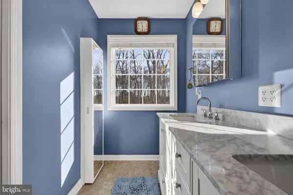 a bathroom with a granite countertop sink and a window