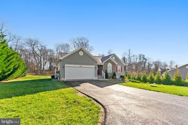 a front view of a house with a yard and trees