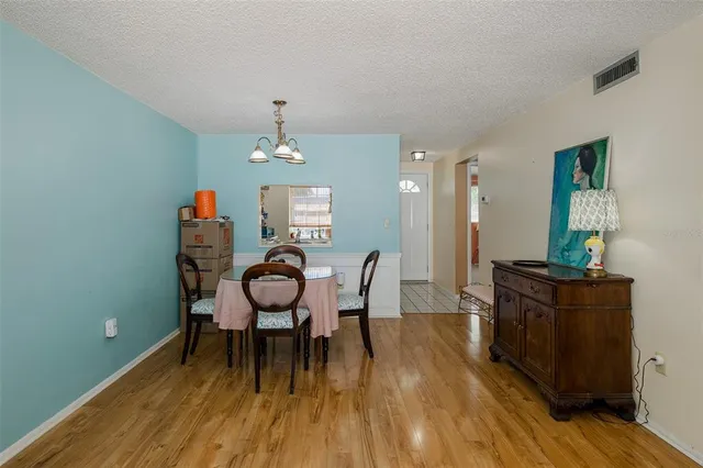 a view of a dining room with furniture wooden floor and chandelier
