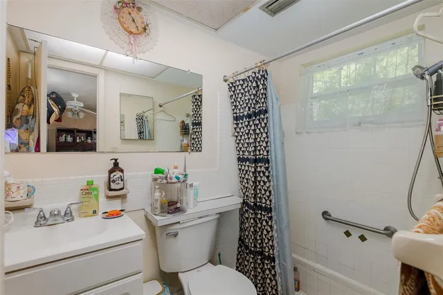a bathroom with a sink toilet vanity and shower