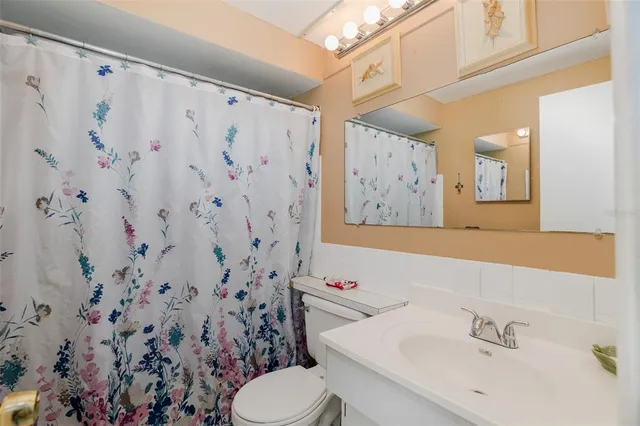 a bathroom with a shower curtain sink and mirror