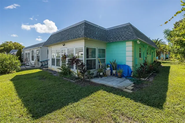 a view of a house with many windows and a table and chairs under an umbrella