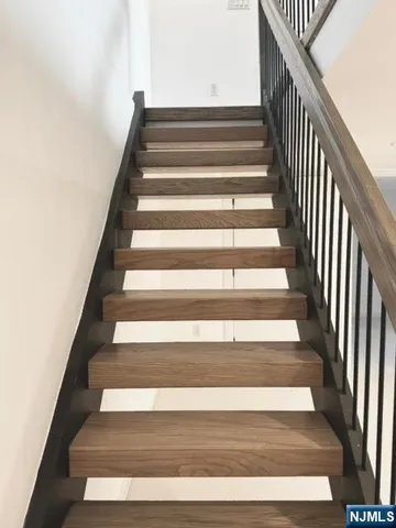 a view of a hallway with wooden floor and closet