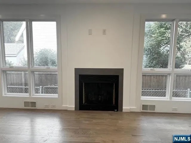 a view of an empty room with a window and a fireplace