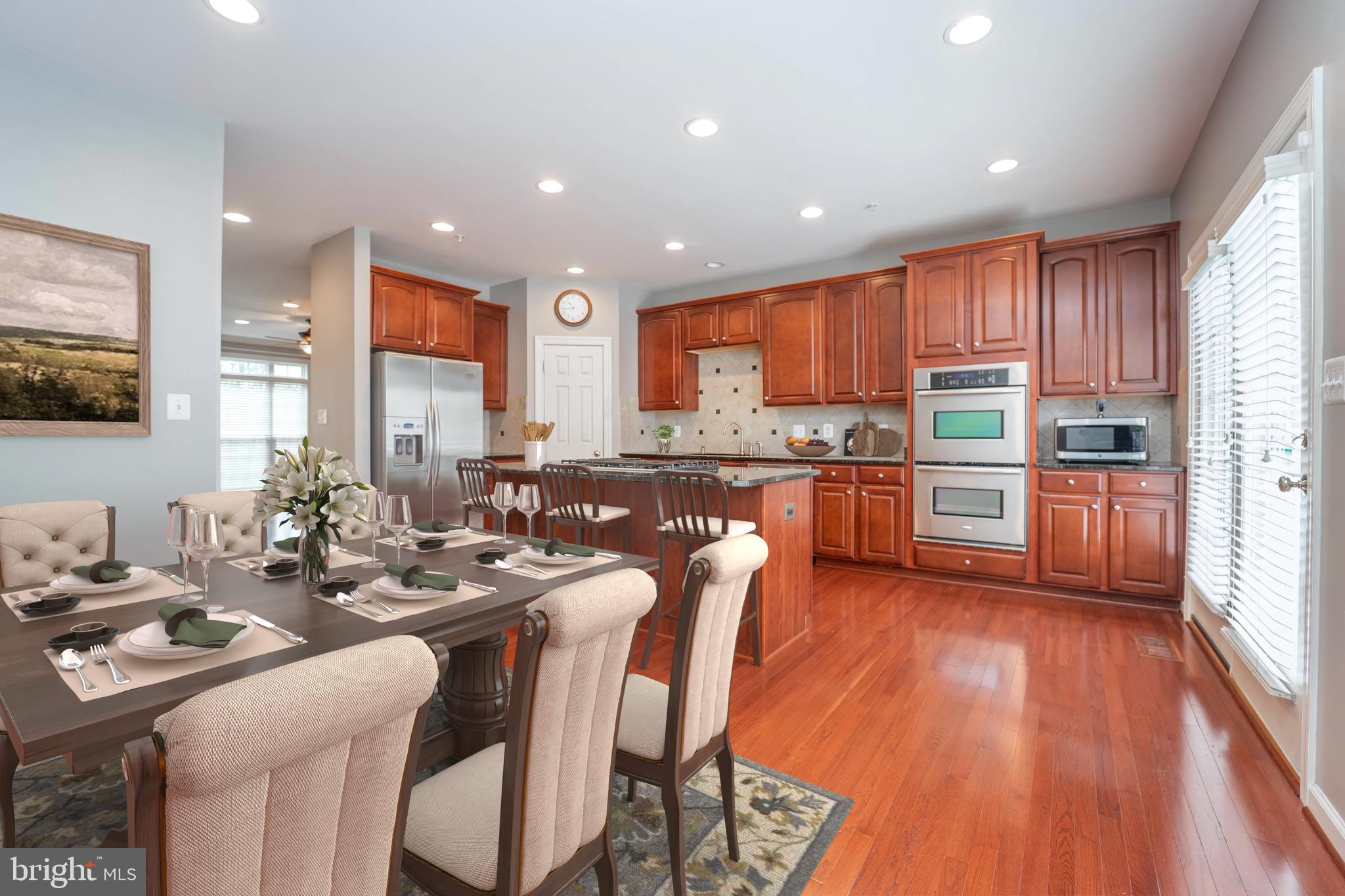 321 Bulwark Alley Annapolis, MD 21401 - Photo 20 of 58 a kitchen with stainless steel appliances granite countertop wooden floor a stove a sink a dining table and chairs
