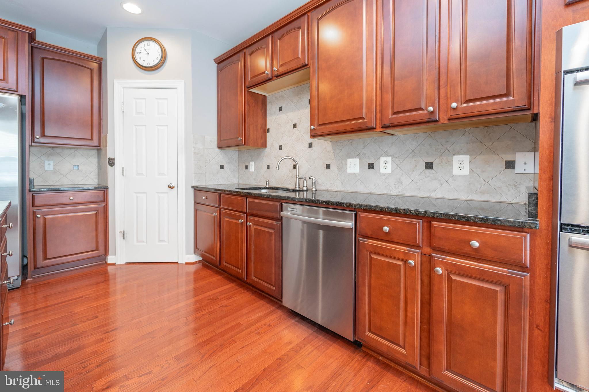 321 Bulwark Alley Annapolis, MD 21401 - Photo 26 of 58 a kitchen with stainless steel appliances granite countertop wooden cabinets and a wooden floor