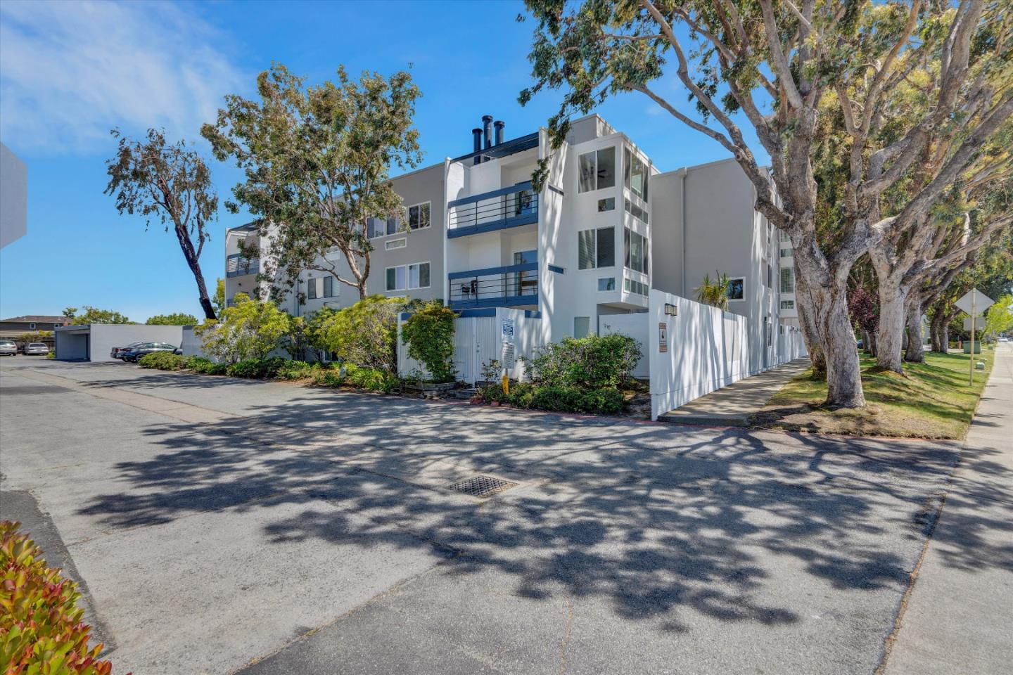 1025 Shell Boulevard, Unit 9 Foster City, CA 94404 - Photo 3 of 31 a view of a white house with a yard and plants