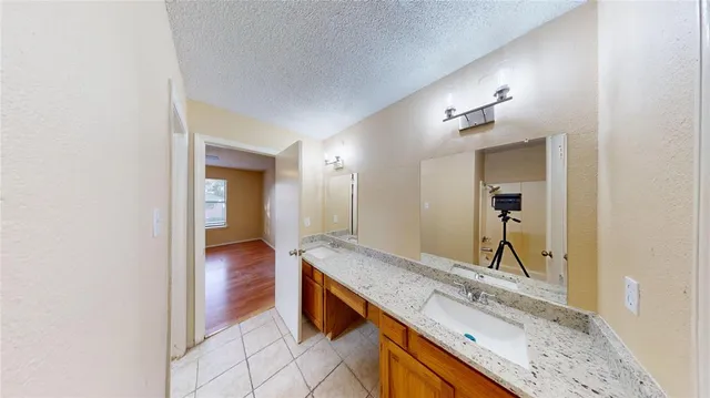 a bathroom with a granite countertop sink and a mirror