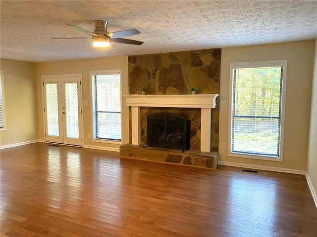 a living room with a fireplace and wooden floor