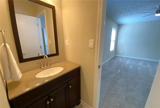 a bathroom with a granite countertop sink toilet and shower