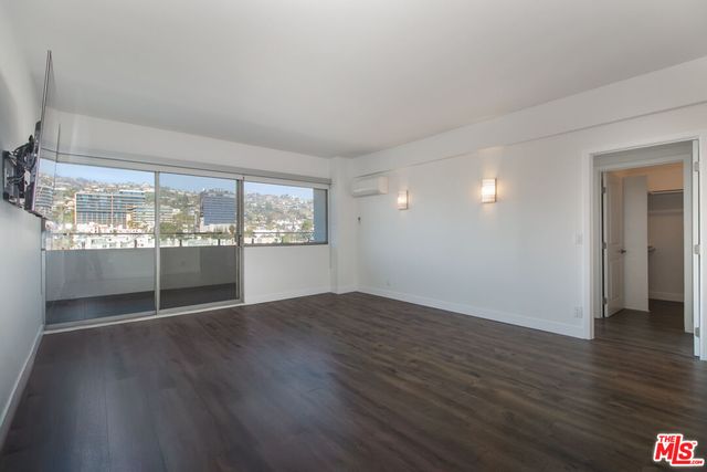a view of a kitchen with wooden floor and a flat screen tv