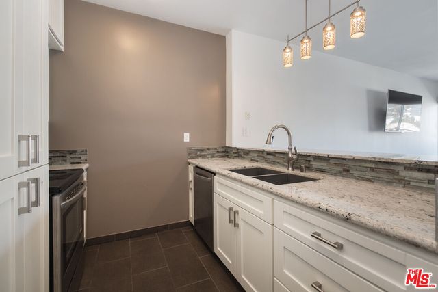 a stove top oven sitting inside of a kitchen