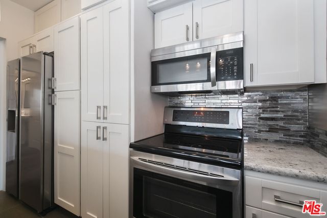 a bedroom with a large bed and a potted plant