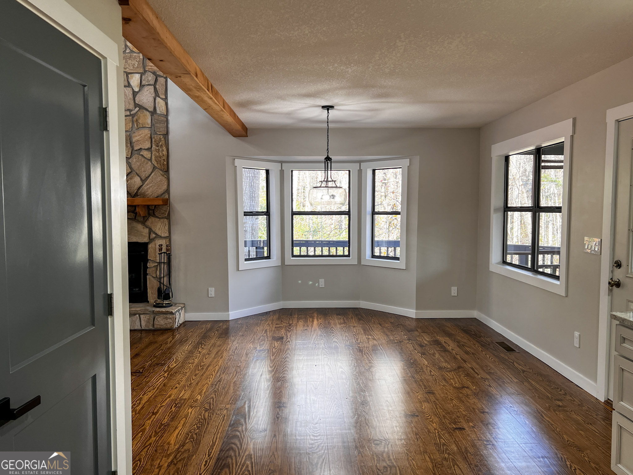 521 Northwind Sautee Nacoochee, GA 30571 - Photo 32 of 66 an empty room with wooden floor chandelier and windows