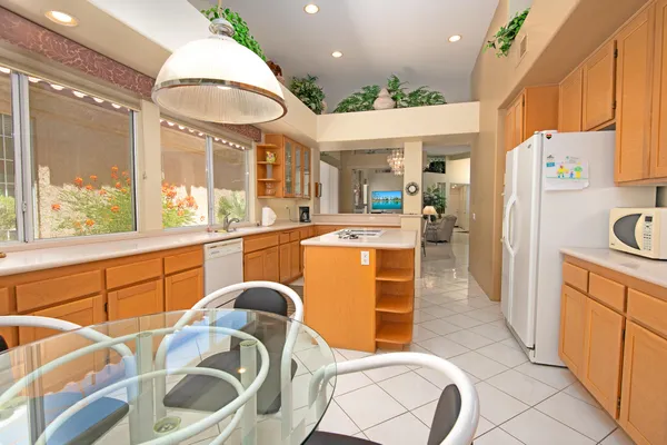a kitchen with stainless steel appliances granite countertop a sink and a refrigerator