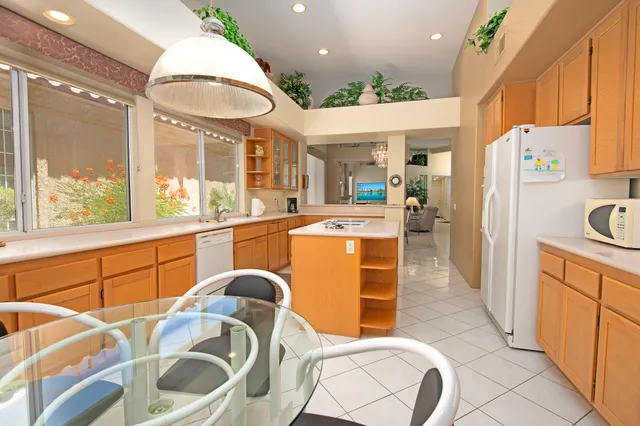 a kitchen with stainless steel appliances granite countertop a sink and a refrigerator
