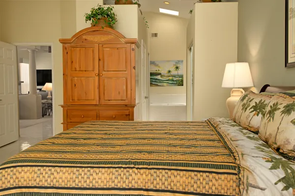 a bedroom with a bed and a mirror on the dresser