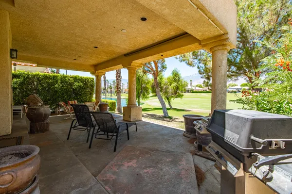 a view of a patio with chairs and floor to ceiling window