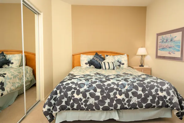 a bedroom with a bed and a painting on the wall