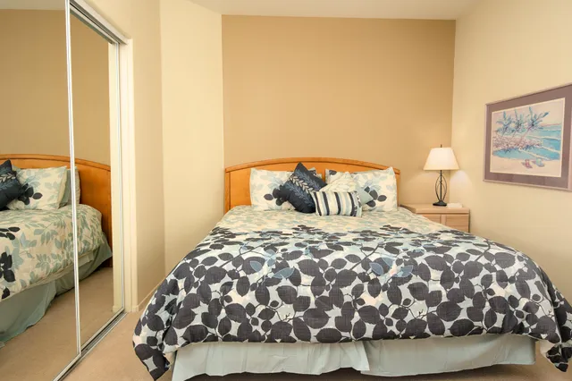 a bedroom with a bed and a painting on the wall