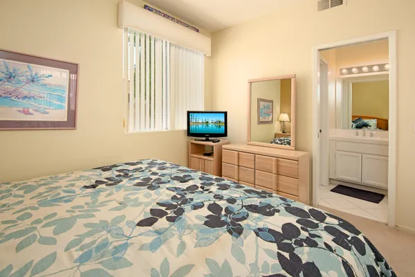 a bedroom with a bed and a view of kitchen