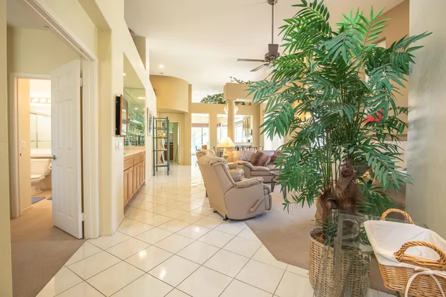 a living room with patio furniture and a potted plant