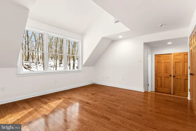 a view of a livingroom with wooden floor and a bathroom