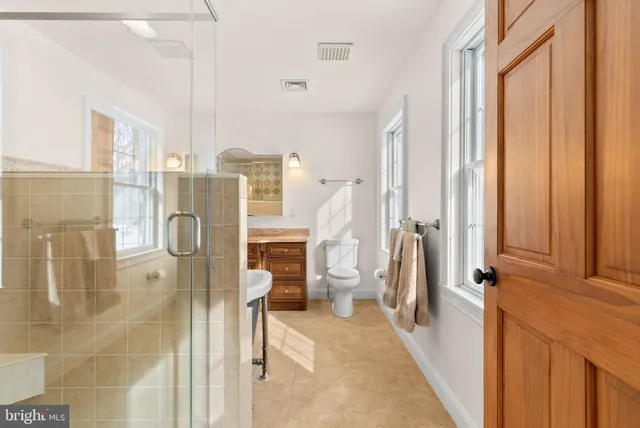 a view of a swimming pool and lounge chairs in back yard of the house