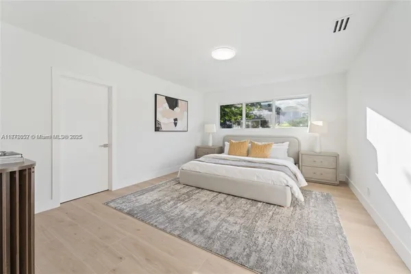 a spacious bedroom with a bed and a window