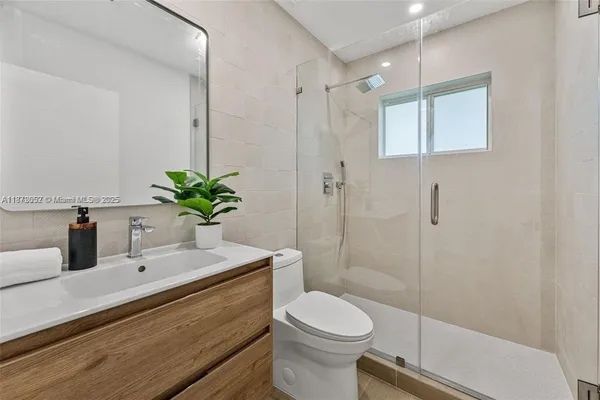 a bathroom with a sink a toilet and shower