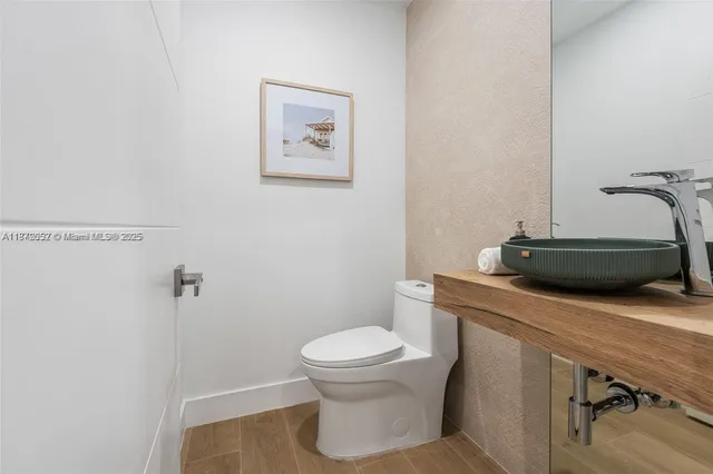 a bathroom with a toilet a sink and a mirror