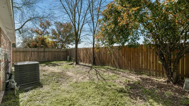 a backyard of a house with table and chairs