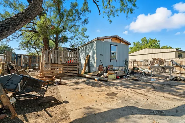 a view of backyard with wheel chair potted plants and large tree