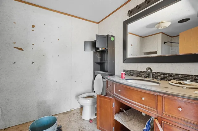 a bathroom with a granite countertop sink a toilet and mirror