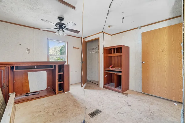 a view of a room with closet and ceiling fan
