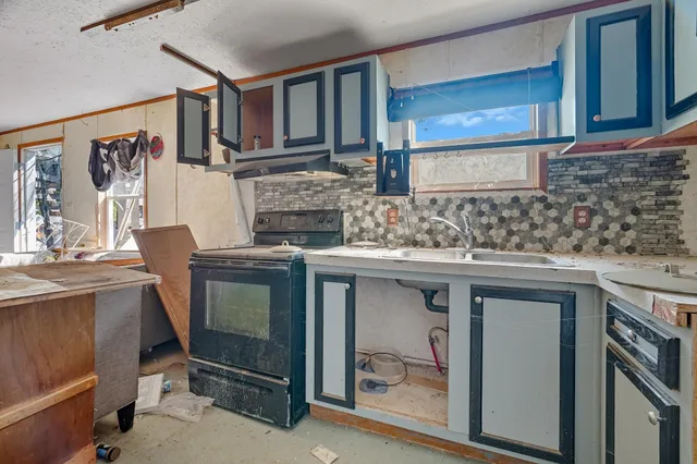 a kitchen with stainless steel appliances granite countertop a sink stove and cabinets