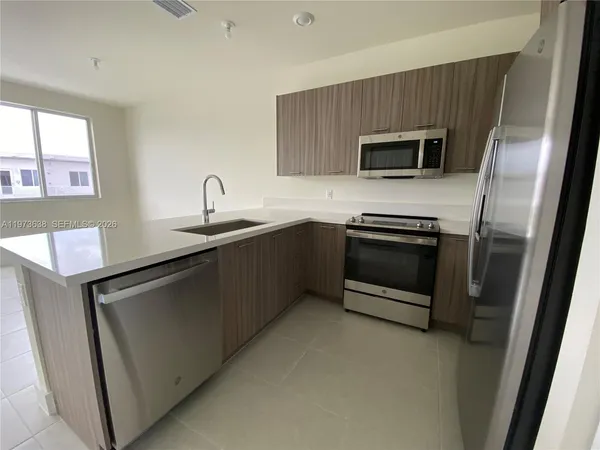 a kitchen with stainless steel appliances a sink stove and microwave