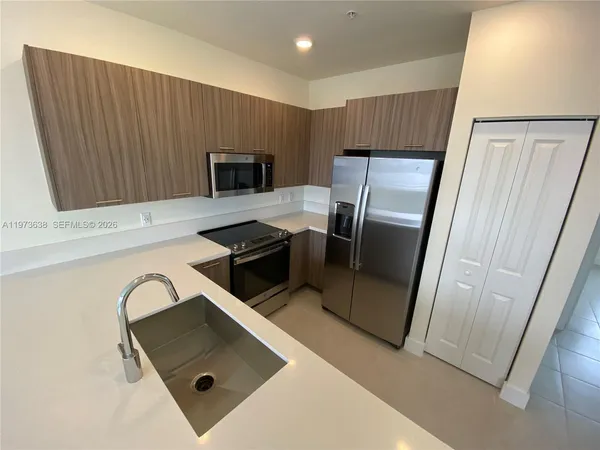 a kitchen with stainless steel appliances granite countertop a refrigerator and a stove top oven