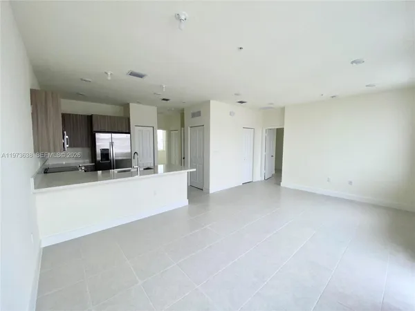 a view of a kitchen with a sink and a refrigerator