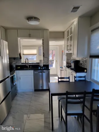 a kitchen with stainless steel appliances a sink a stove a refrigerator a counter top space and cabinets