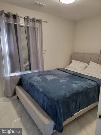 a large bed sitting in a room next to a window