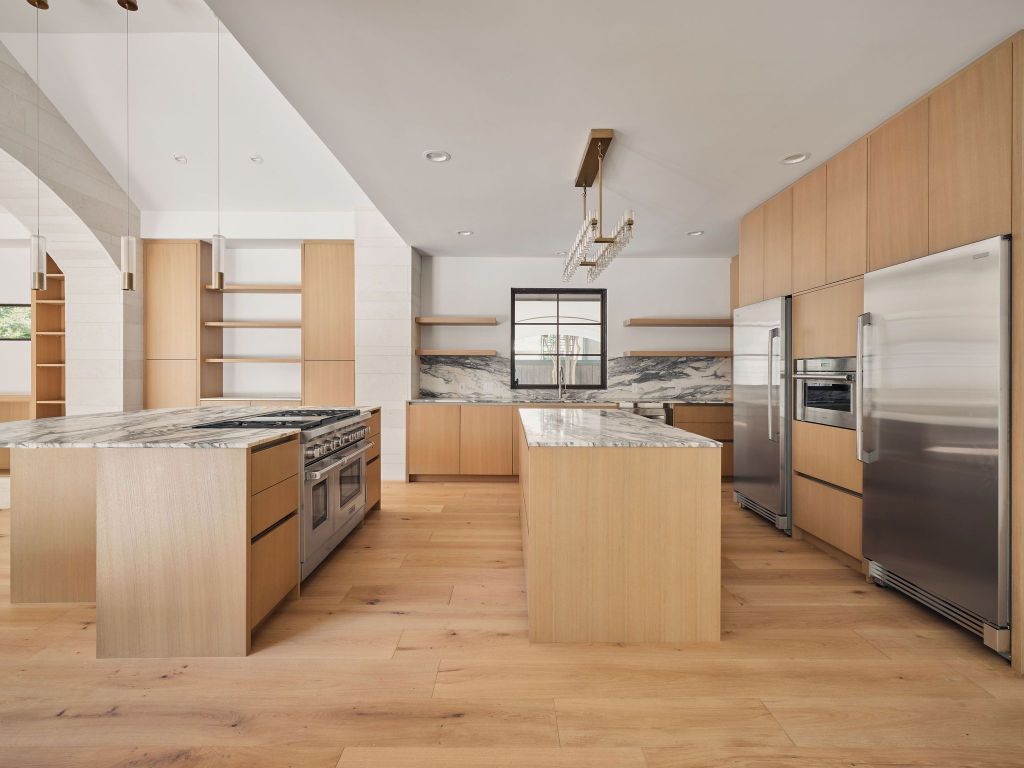 13 Niles Road Austin, TX 78703 - Photo 14 of 40 a large kitchen with stainless steel appliances granite countertop a stove a sink dishwasher a refrigerator and white cabinets with wooden floor