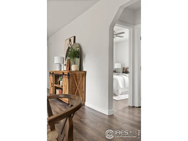 a view of a hallway with wooden floor and a bathroom view