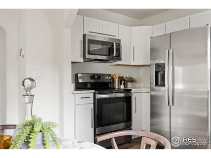 a kitchen with stainless steel appliances kitchen island granite countertop a refrigerator and a stove top oven