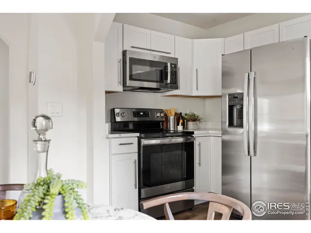 a kitchen with stainless steel appliances kitchen island granite countertop a refrigerator and a stove top oven