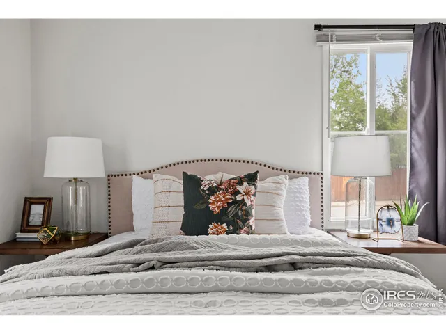 a view of a bedroom with a bed and a lamp