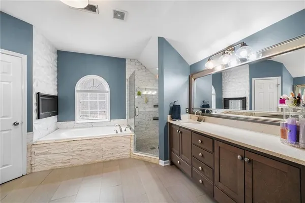 a spacious bathroom with a tub sink and mirror