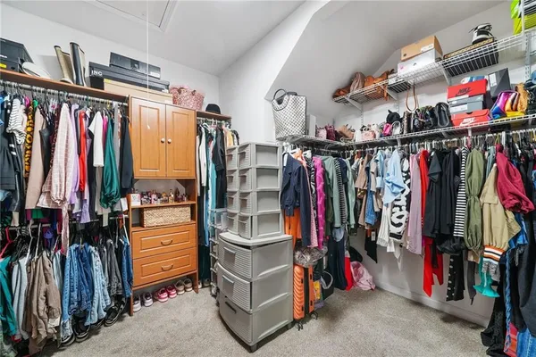 a view of walk in closet with clothes