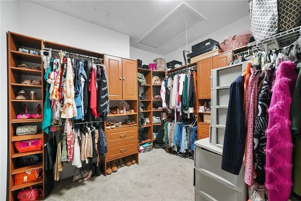 a view of walk in closet with clothes and shoes