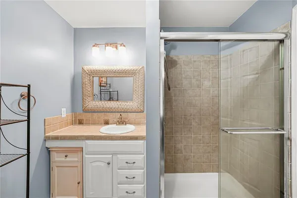 a bathroom with a granite countertop sink toilet and shower